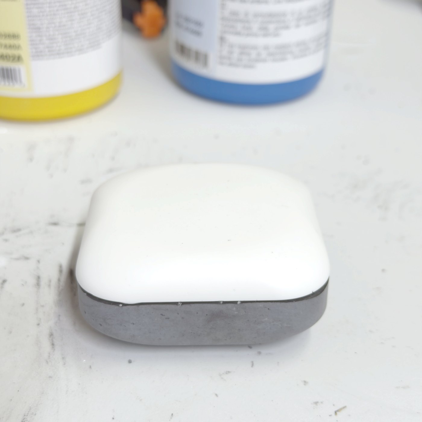 The finished stone on the workshop bench: grey concrete body, white dome.